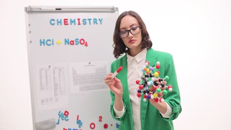 woman teaching chemistry with molecular model and whiteboard