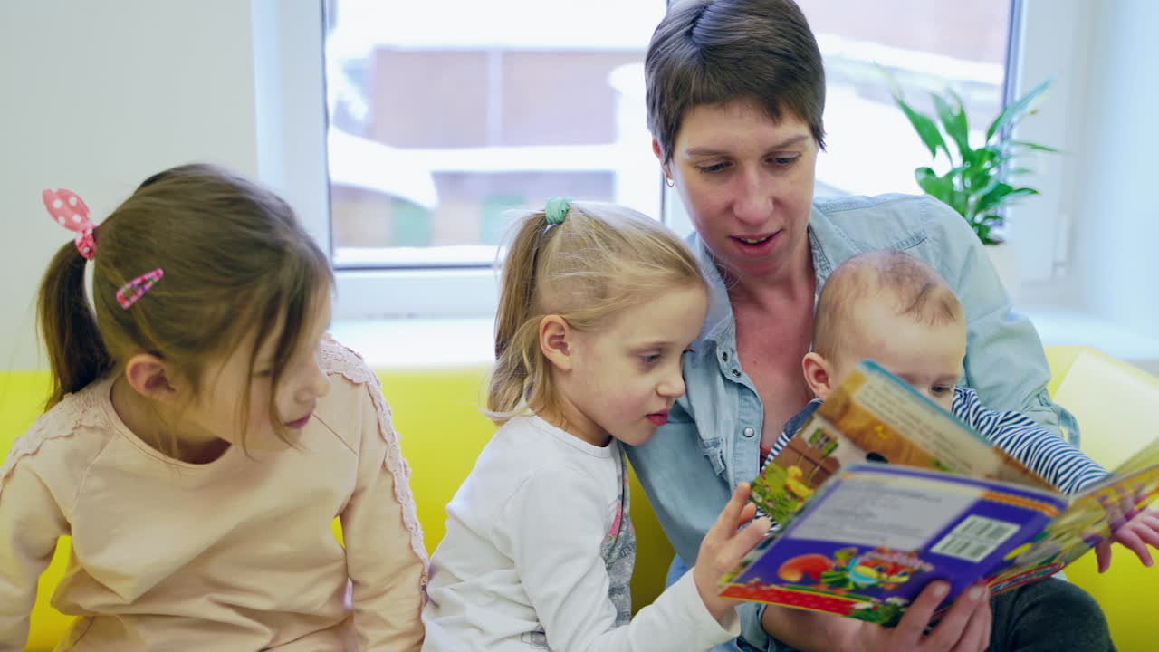Children reading book. Young mother with children reading book