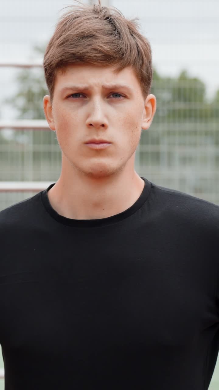 Man standing outside in athletic wear with serious expression