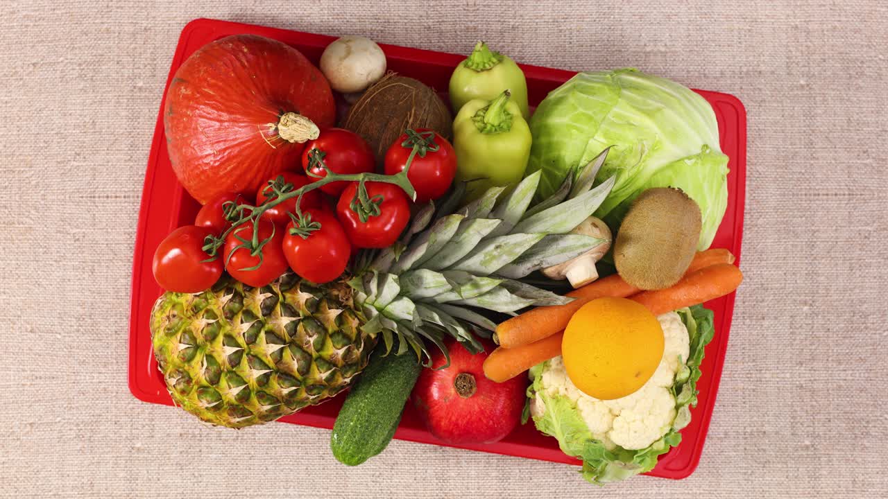 Red tray full with fruits and vegetables moving. Stop motion