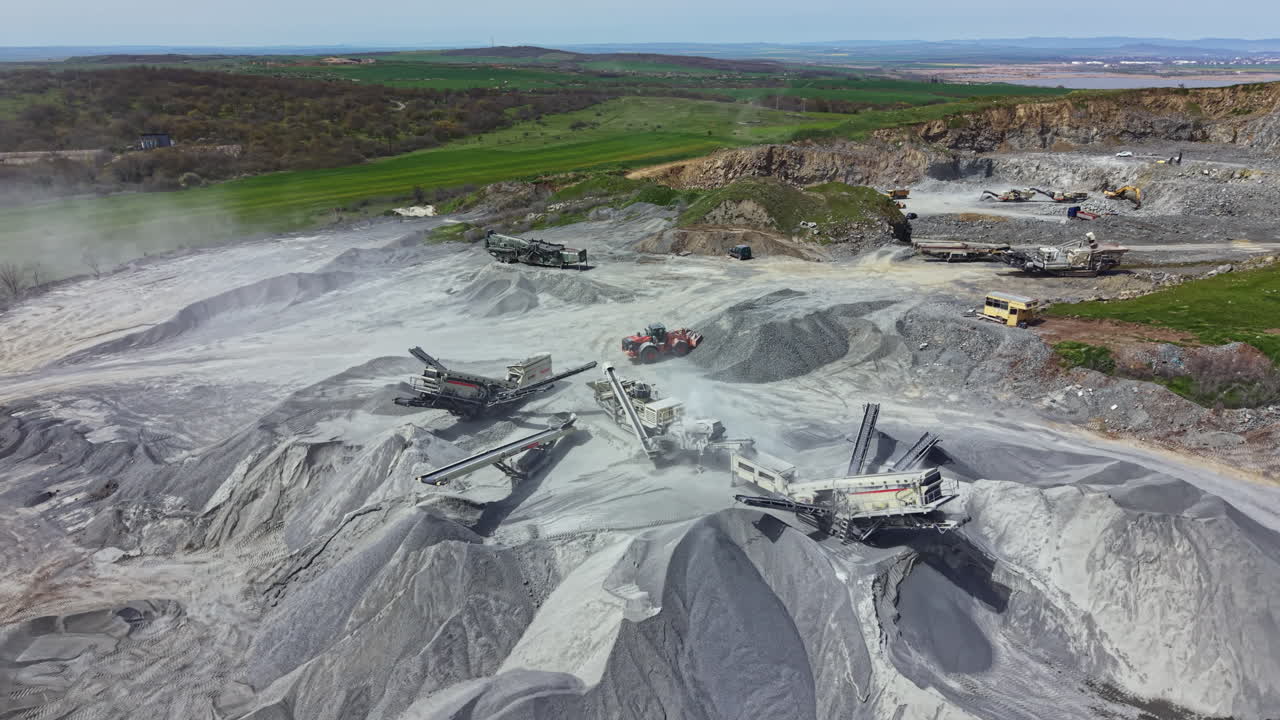 Heavy machinery works in granite quarry during daylight at construction site in rural area of the country