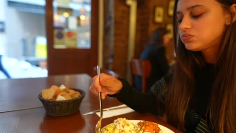 mujer comiendo una comida en un restaurante