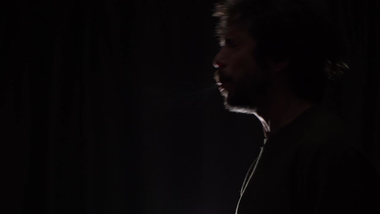 A man sneezing into the air releasing infected droplets