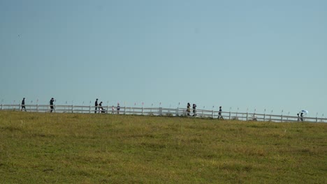 Tourists-Walking-Beyond-The-Wooden-Fence-At-Anseong-Farmland-In-Gyeonggi-do,-South-Korea