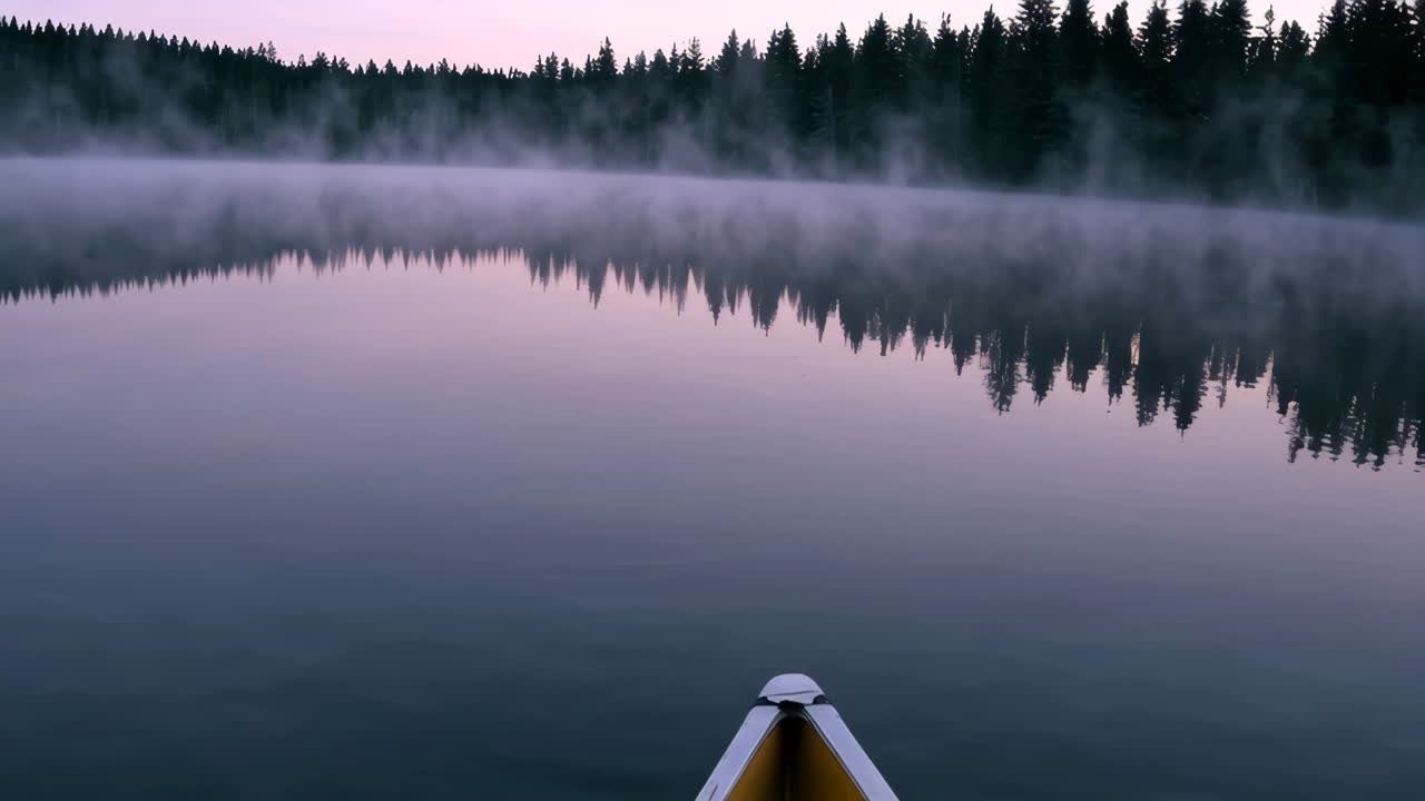 Misty Sunrise Canoe Ride on a Calm Lake