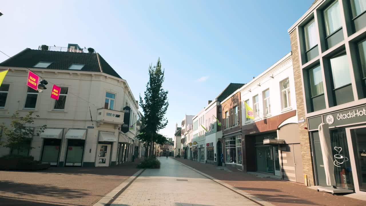 Peaceful view of Langstraat in Weert during an empty Sunday morning. The street is bathed in sunlight, showcasing the serene atmosphere of the historic city. Location: Weert, Limburg, Netherlands