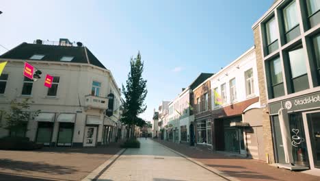 peaceful view of langstraat in weert during an empty sunday morning. the street is bathed in sunlight, showcasing the serene atmosphere of the historic city. location: weert, limburg, netherlands