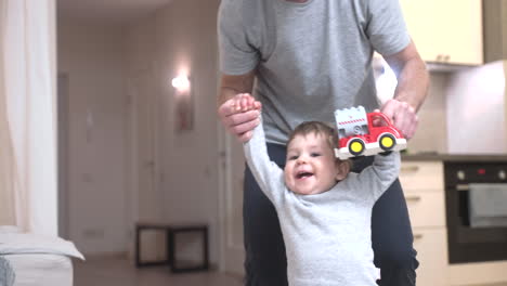padre ayudando a su hijo a dar sus primeros pasos