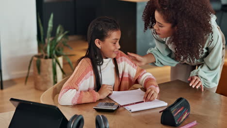 mother helping daughter with homework at home