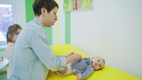 professional pediatrician examining infant. female doctor examining baby boy in clinic