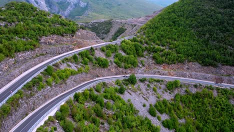 Aerial-pan-of-hairpin-bend-in-road-Albanian-alps-mountains-epic-landscape