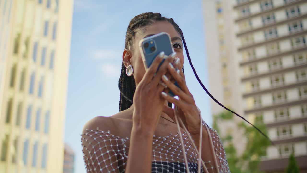 dama feliz escuchando mensaje de voz en el frente del edificio de la ciudad urbana de primer plano