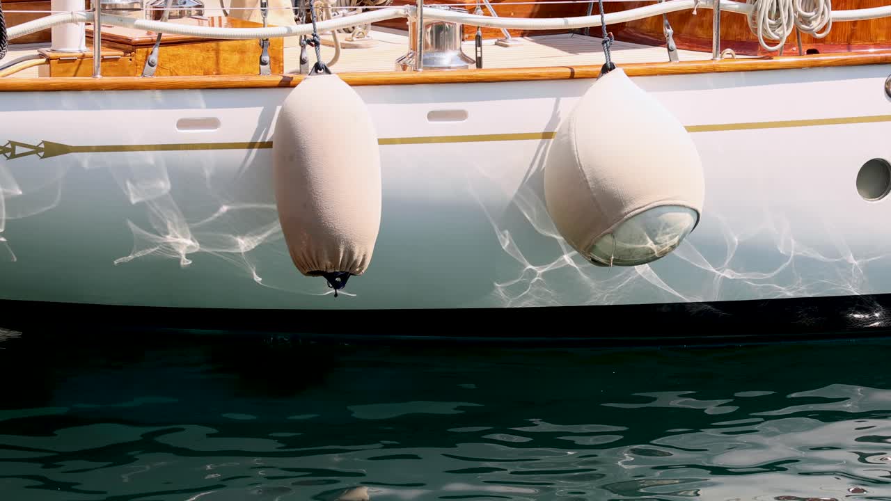 배의 펜더가 물 표면에 반사됩니다.