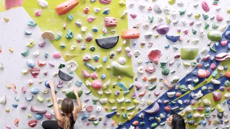 Frauen-Klettern-Boulderwand-Mit-Bunten-Griffen