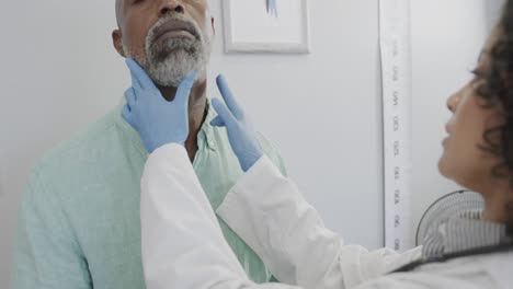 Diverse-female-doctor-examining-male-patient-in-consulting-room,-slow-motion