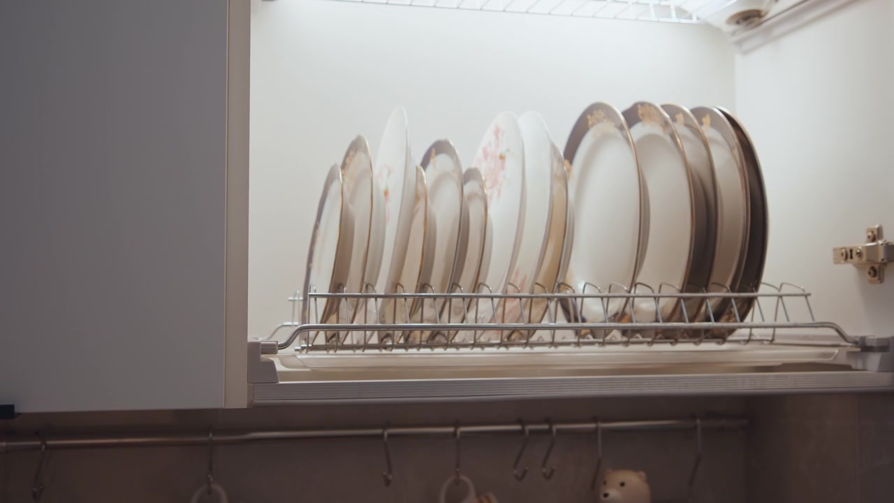Sistemazione dei piatti dopo il pasto. Attenta disposizione dei piatti in cucina dopo la preparazione del pasto. Pulizia e organizzazione sistematica delle stoviglie da cucina dopo cena e le attività di cottura.