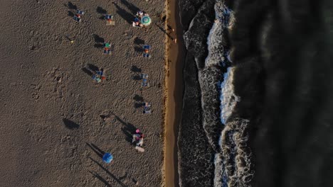 Goldene-Stunde-Des-Sonnenuntergangs-Am-Strand-Mit-Sand-Und-Sonnenschirmen-In-Der-Nähe-Von-Meereswellen-Am-Abend-An-Der-Adriaküste