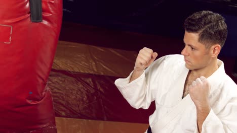 man practicing karate with punching bag