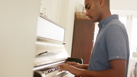 Hombre-Birracial-Tocando-El-Piano-En-Casa,-Cámara-Lenta