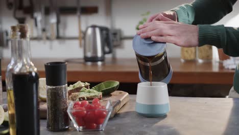 Hands-of-caucasian-man-making-coffee-in-kitchen,-slow-motion