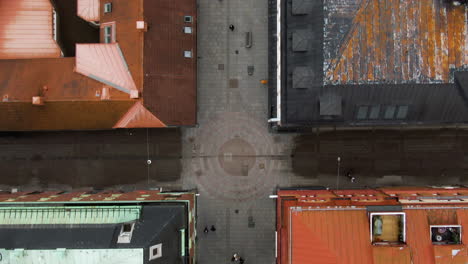 Colorful-Swedish-town-center-with-people-walking,-aerial-top-down-view