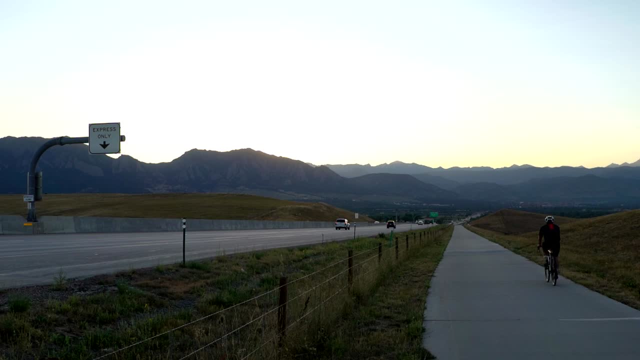 슬로우 모션으로 고속도로를 따라 자전거 트레일을 타고 있는 바이커