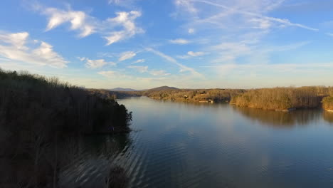 Rising-drone-shot-over-Smith-Mountain-Lake-in-Virginia-with-sunshine-and-blue-skies