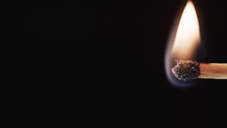 video of match with yellow fire flame and copy space on black background