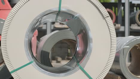 el conductor de la carretilla elevadora carga rollos de chapa de acero. almacén industrial con rollos de láminas de acero