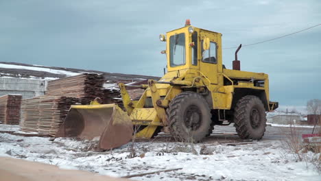 yellow tractor in a snowy construction site