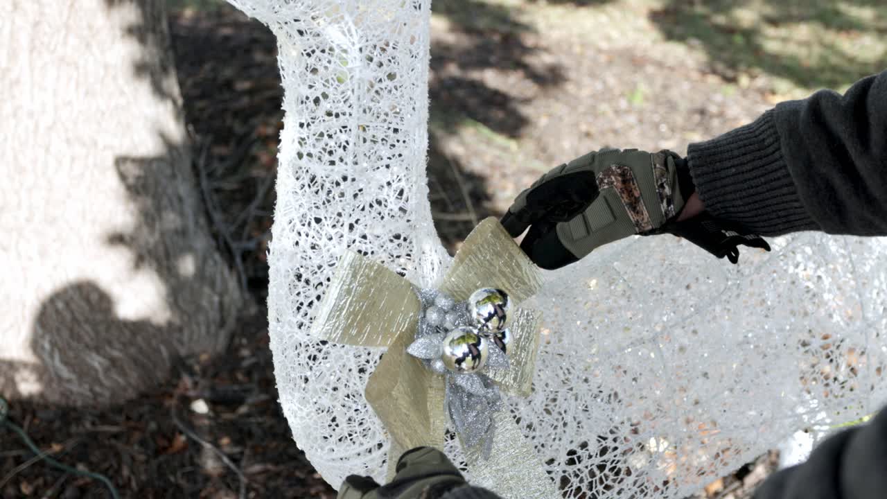 장갑 크리스마스 순록에 활을 조정하는 남자