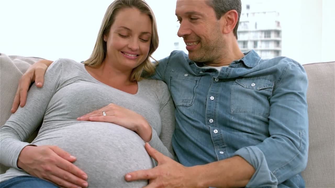 Happy future parents on sofa