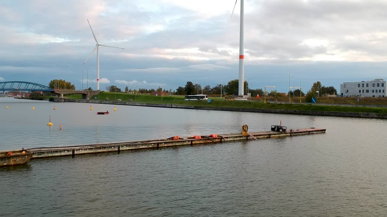 무인 항공기는 schelde 강 옆에 있는 해안의 구름으로 덮인 풍차에서 끌어옵니다.