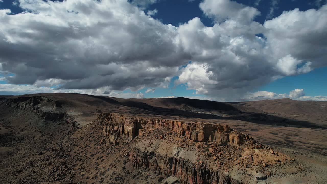 Ripresa aerea cinematografica di nuvole scure che passano sopra una scogliera in Patagonia.