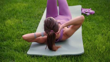mujer haciendo ejercicios abdominales al aire libre