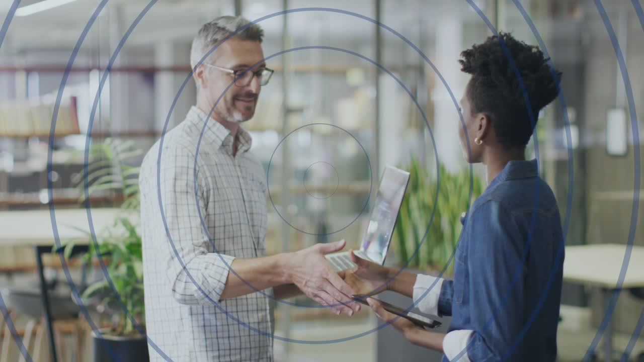 Manager pointing at laptop guiding colleague with smartphone shaking hands concluding business deal