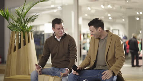Two friends laughing and having fun together in a shopping mall