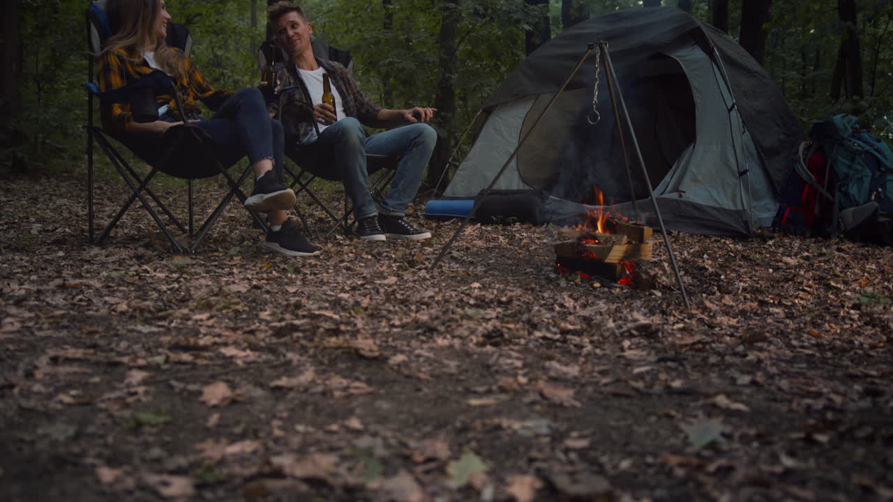pareja acampando y disfrutando de una fogata