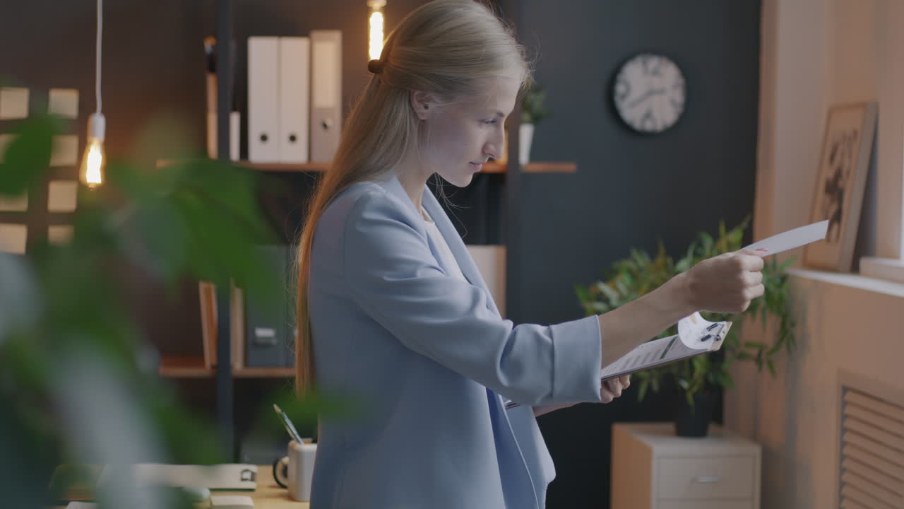 деловая женщина, рассматривающая документы в современном офисе.