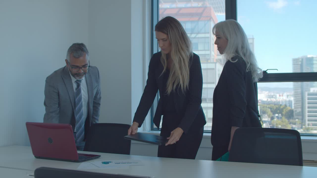 Group of colleagues talking while walking to meeting table