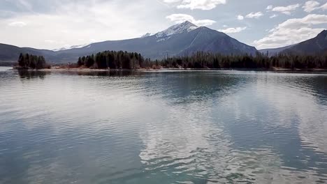 drone footage flying fast over the surface of a winter mountain lake in the maroon bells aspen mountain range in colorado