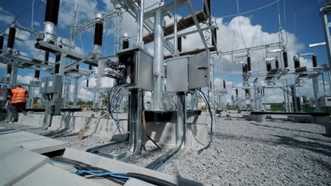 many high voltage electrical insulators in power substation against blue sky background