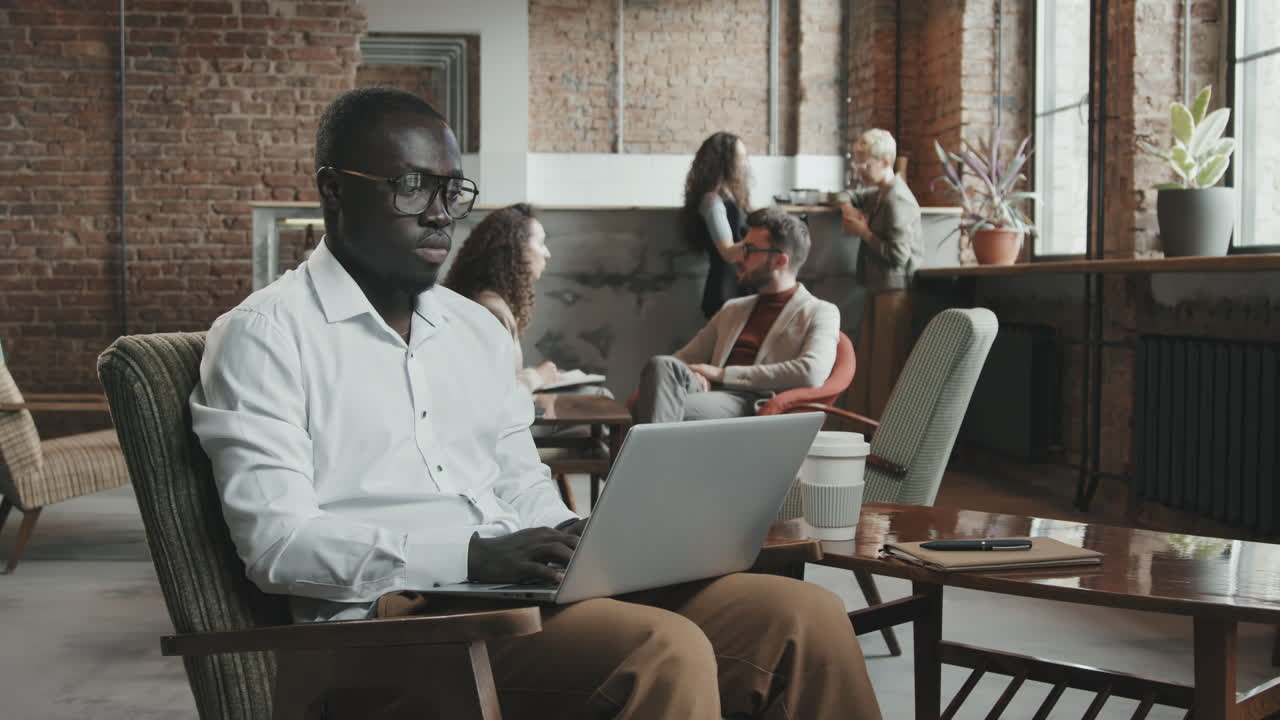 African-American Man Working on Laptop in Coworking Office