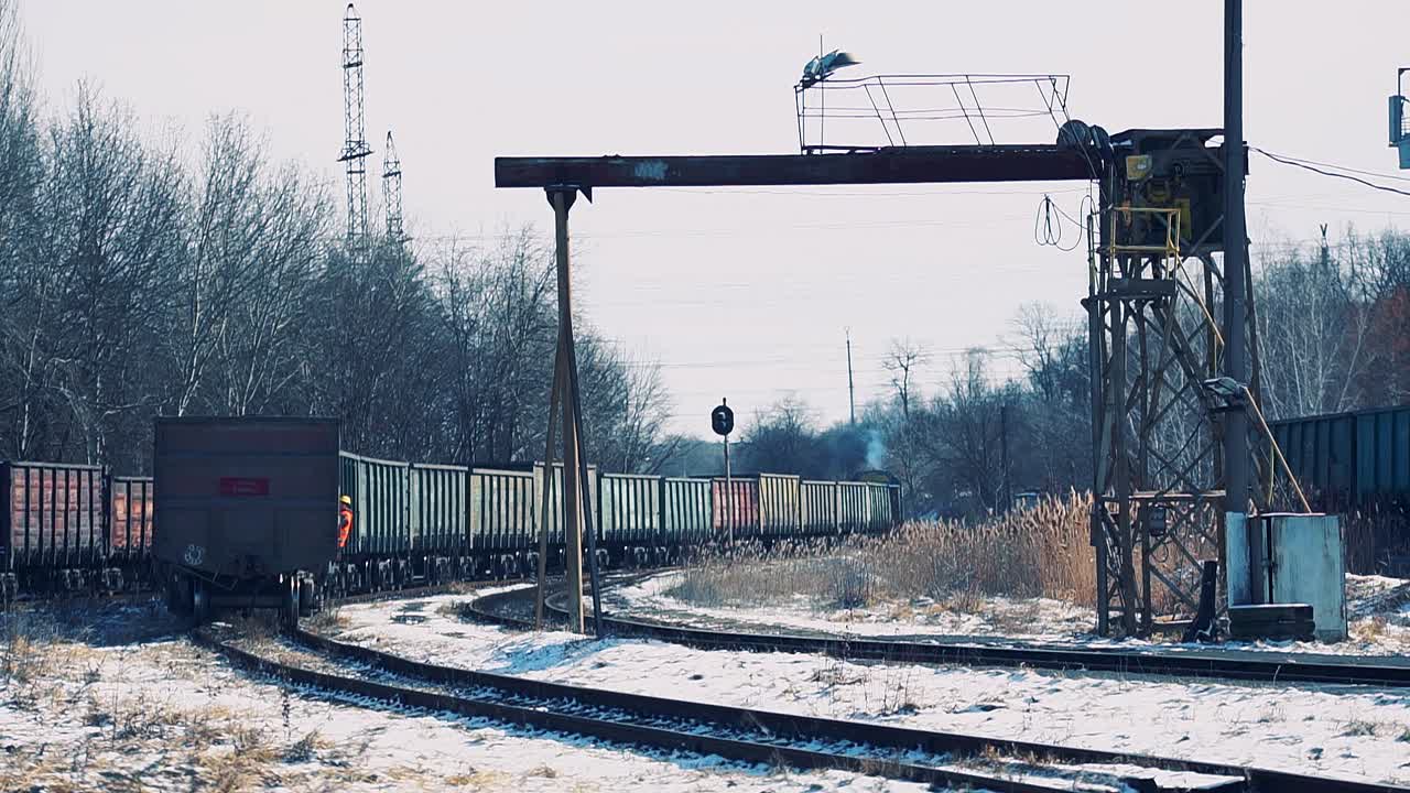 눈 덮인 철도역을 따라 화물차를 실은 디젤 기차가 움직이고 있어요