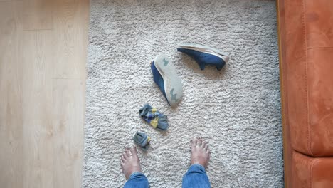 man taking off his shoes and socks at home