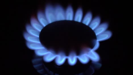 gas stove turned on and off with blue flames fire in the dark