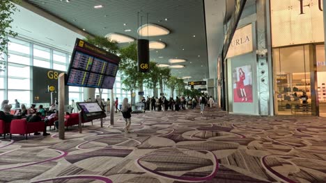 passengers walking through a busy airport terminal.