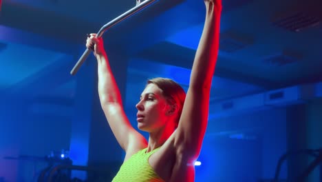 woman performing pull-ups in a gym