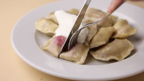 comiendo pierogi con crema agria