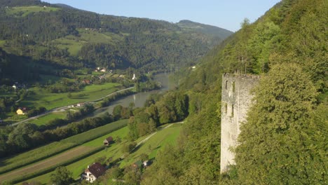 aerial view of old puchenstein castle tower ruin overlooking dravograd landscape in slovenia